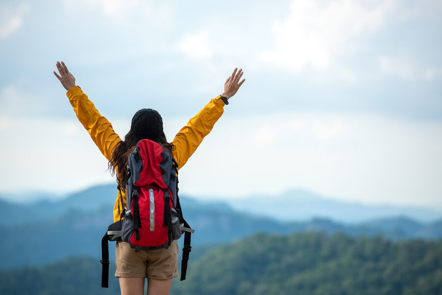 Wanderin mit erhobenen Armen am Berg